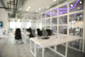 Blurred view of cozy workspaces with tables and chairs in office photo