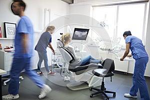 Blurred view of dentists and woman in dentist`s clinic