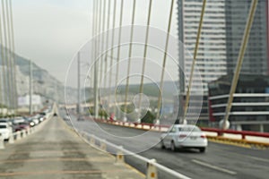 Blurred view of modern bridge and cars near mountain photo