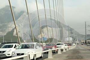 Blurred view of modern bridge and cars near mountain photo