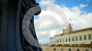 Blurred view of the Quirinal Palace from behind a lamp post in focus