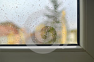 Blurred view on a rainy day through the window. Raindrops on the glass window.