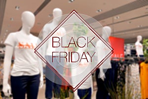 Blurred view of retail store sale display with Black Friday text overlay