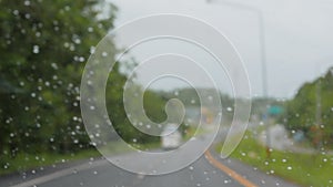 Blurred view from the running car through the windshield on the road during rainy the trip