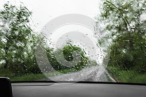 Blurred view of suburban road through wet car window