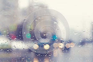 Blurred view through the windshield of a car with raindrops at a crossroad