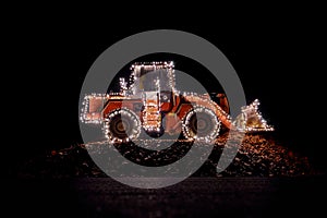 Blurred wheel loader decorated with lights at christmas
