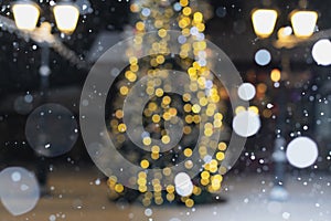 Blurred winter holiday background  falling snow on the background of a Christmas tree decorated