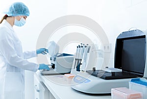 Blurred woman using professional medical equipment in lab