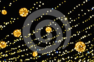 Blurred Yellow Christmas lights on a black background. Yellow garland. New Year\'s illumination. Concept of New Year