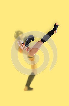 Blurring effect. Portrait of young female kickboxer in sports uniform and protective equipment practicing punch. Combat