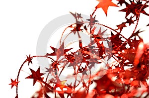 Blurry abstract background of red Christmas garland with red stars on white