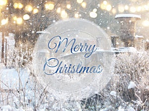 Blurry and abstract magical winter landscape photo with greeting text: Merry Christmas. Glitter overlay.