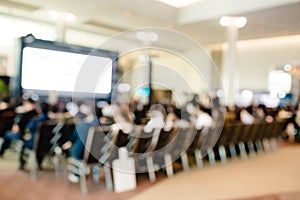 Blurry of auditorium for shareholders` meeting or seminar event with projector and white screen