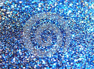 Blurry background of blue, black, golden and red glitter sparkle