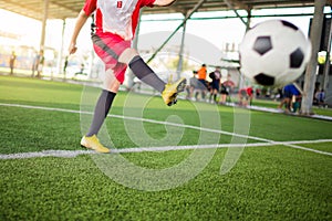 Blurry ball after boy soccer player speed run on green artificial turf to shoot it to goal.