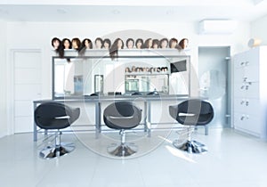 Blurry barber shop interior with wigs on mannequins