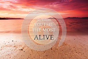 Blurry beach at sunset background with Inspirational quote - Go where you feel the most alive