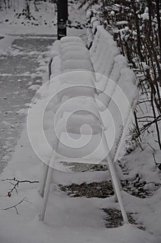 Blurry chairs in a snowy garden in mountain.Snowy garden furniture, symbolizing winter, winter break.