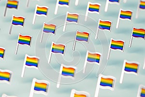 Blurry close-up focus on Rainbow LGBTQ flags pattern. June the gay pride month symbol concept.  on pastel green background