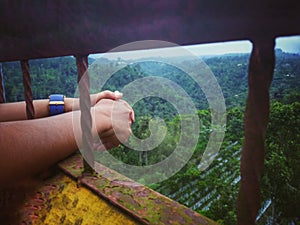 Blurry concept background of imprisoned hands and fresh green nature view. People in jail concept