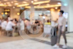 Blurry image of airport coffee shop or cafe restaurant with travelers for background