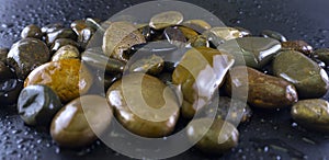 Blurry images groups of rocks and damp water droplets scattered on a black background