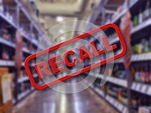 Blurry interior of a liquor store aisle behind large red Recall text