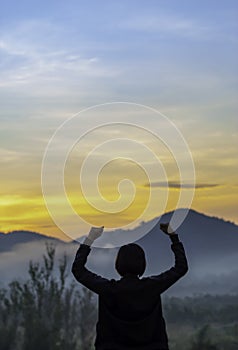 Blurry morning sun light behind the mountains and Women raise their arms