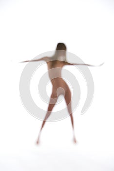 Blurry naked woman dancing on a white backdrop