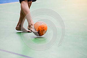 Blurry orange ball after futsal player shoot it to goal. Indoor soccer sports hall