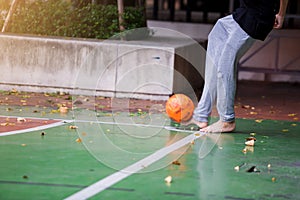 Blurry orange ball after futsal players shoot it at conner. Futsal players wearing sweatpants and barefoot