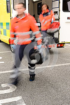 Blurry paramedics getting out from ambulance car photo