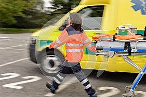 Blurry paramedics pulling gurney ambulance car