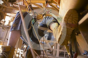 Blurry picture of rope access miner working at height hangin on two rope commencing ascending using foot loop step by step photo