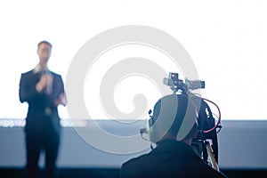 Blurry picture of video camera set record speaker and audience in conference hall seminar event. Company meeting, exhibition