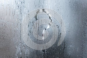Blurry question mark on foggy condensation window glass natural surface photo