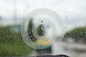 Blurry rain drop on window front car on the road. storm rain dangerous for driving car.