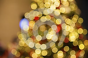 Blurry red Christmas balls on artificial Christmas tree.Christmas Holiday Blurred Background.