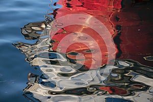 Blurry reflection of red boat bow