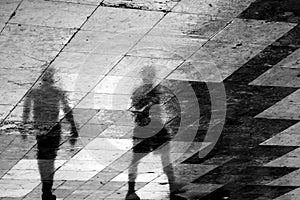 Blurry reflection silhouette of two people walking together in t