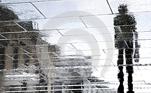 Blurry reflection silhouettes of people walking on a rainy day