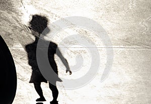 Blurry shadow silhouette of a little girl walking alone on a summer day