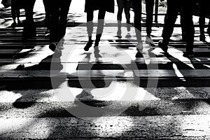 Blurry shadows and silhouettes of people on crossroad