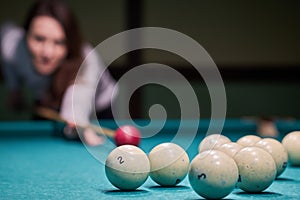 Blurry silhouette of a girl playing billiards