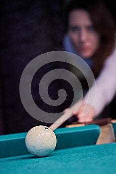 Blurry silhouette of a girl playing billiards