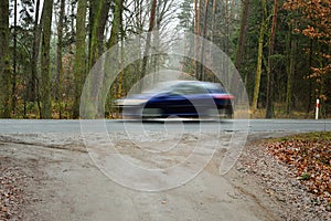 Blurry silhouettes of cars during movement in long time exposure on a sunny morning.