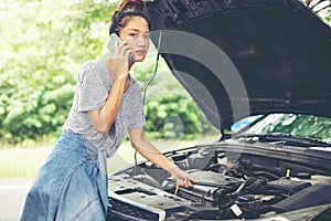 Blurry and soft focus of Asian woman using mobile phone while looking and Stressed man sitting after a car breakdown on street