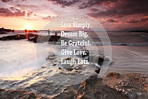 Blurry sunset on the beach with Inspirational quote - Live simply , dream big, be grateful, give love, laugh lots