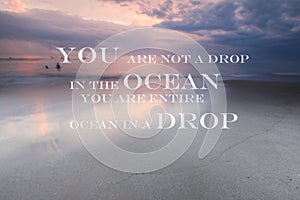 Blurry sunset on the beach with Inspirational quote You are not a drop in the ocean you are entire ocean in a drop